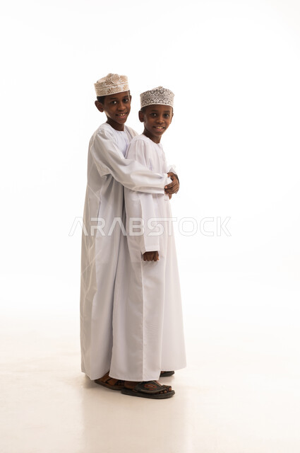 Omani Boys in Traditional Dishdasha on White Background