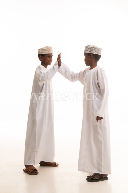 Omani Boys in Traditional Dress Giving High Five