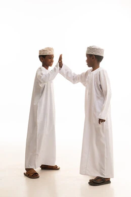 أطفال عمانيون بالزي التقليدي يتبادلون التحية