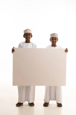 أطفال عمانيون يحملون لوحة بيضاء فارغة في استوديو