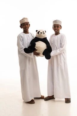 أطفال عمانيون بالزي التقليدي مع لعبة الباندا