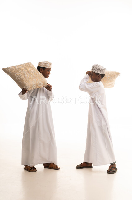 Omani Boys in Traditional Dress Playing with Pillows
