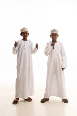 أطفال عمانيون بالزي التقليدي مع ميكروفون