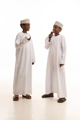 أطفال عمانيون بالزي التقليدي مع ميكروفون في استوديو