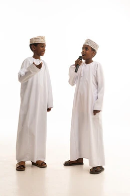 أطفال عمانيون بالزي التقليدي مع ميكروفون