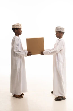 أطفال عمانيون يحملون صندوقاً كرتونياً في الاستوديو