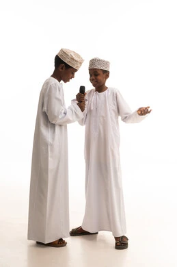 أطفال عمانيون يجرون مقابلة بالميكروفون في استوديو