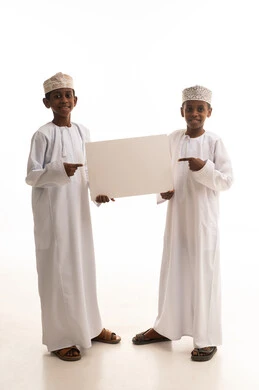 أولاد عمانيون يحملون لوحة بيضاء فارغة بخلفية بيضاء