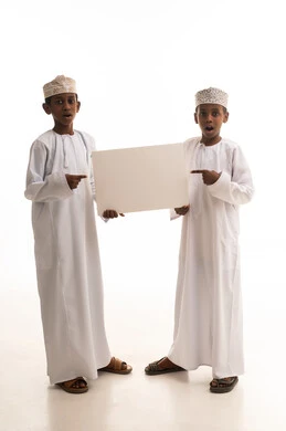 أطفال عمانيون يحملون لوحة بيضاء فارغة في استوديو