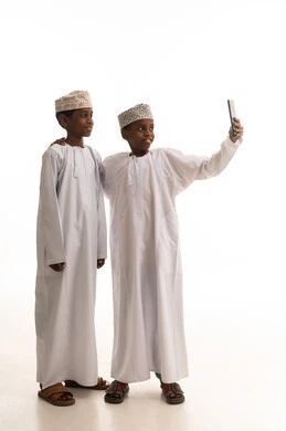 أطفال عمانيون بالزي التقليدي يلتقطون سيلفي