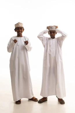 أطفال عُمانيون بالزي التقليدي في استوديو بخلفية بيضاء