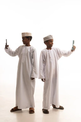 أطفال عمانيون بالزي التقليدي يلتقطون سيلفي