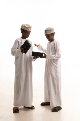 أطفال عمانيون بالزي التقليدي مع صندوق هدايا