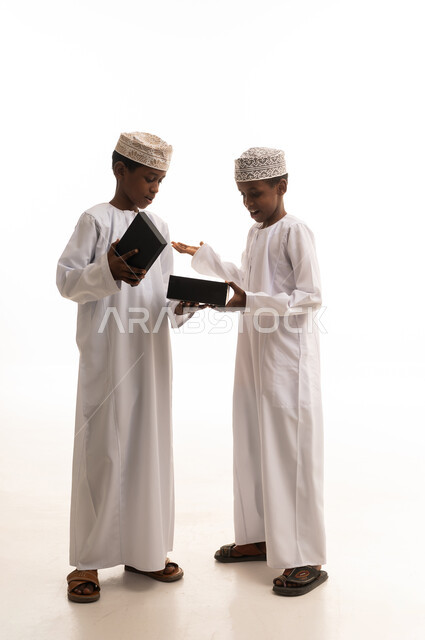 أطفال عمانيون بالزي التقليدي مع صندوق هدايا