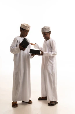 أطفال عمانيون بالزي التقليدي مع صندوق هدايا