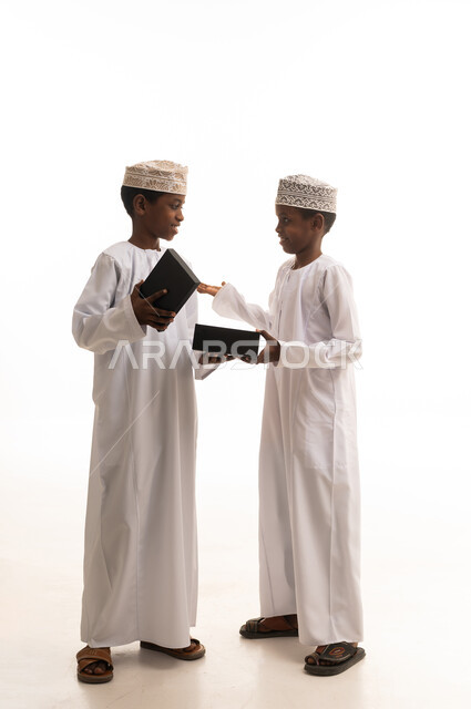 أولاد عمانيون بالزي التقليدي مع صناديق هدايا