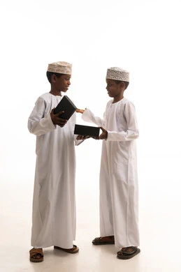 أولاد عمانيون بالزي التقليدي مع صناديق هدايا