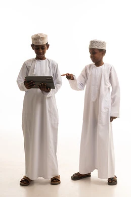 أطفال عمانيون يستخدمون جهازاً لوحياً في الاستوديو