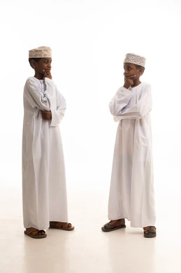 أطفال عمانيون بالزي التقليدي في وضعية تفكير