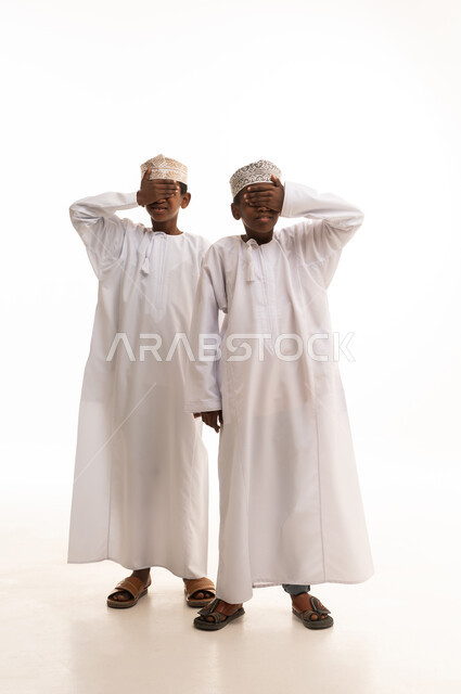Two Omani Boys in Traditional Dress on White Background