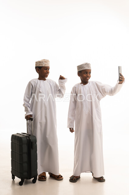 Omani Boys Taking Selfie with Suitcase on White Background