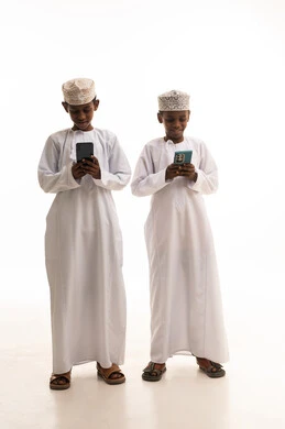 Omani Boys Using Smartphones in Traditional Dress
