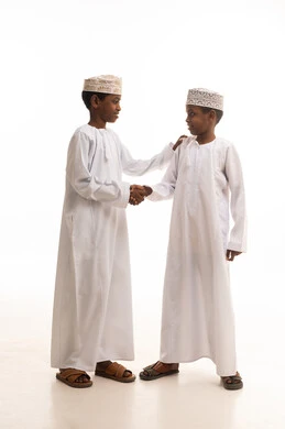 أطفال عمانيون بالزي التقليدي يتصافحان في الاستوديو