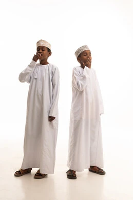 أطفال عمانيون بالزي التقليدي في حالة تثاؤب ونعاس أطفال عمانيون بالزي التقليدي في حالة تثاؤب ونعاس