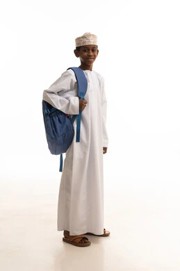 طالب عماني بالزي التقليدي مع حقيبة مدرسية