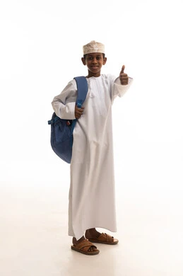 طالب عماني بالزي التقليدي مع حقيبة مدرسية