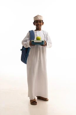 طالب مدرسي عماني يحمل صندوق غداء في استوديو خلفية بيضاء
