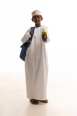 طالب عماني يحمل تفاحة خضراء في الاستوديو