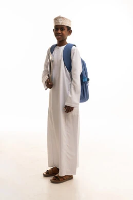 طالب عُماني بالزي التقليدي مع حقيبة مدرسية