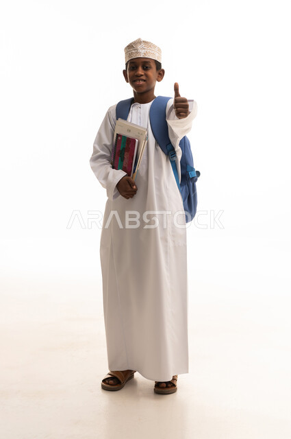 طالب عماني يرتدي الزي التقليدي مع حقيبة مدرسية