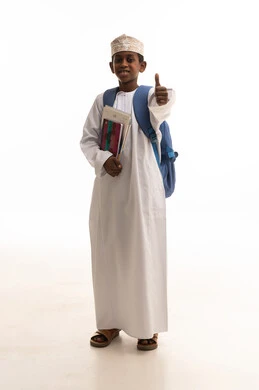 طالب عماني يرتدي الزي التقليدي مع حقيبة مدرسية