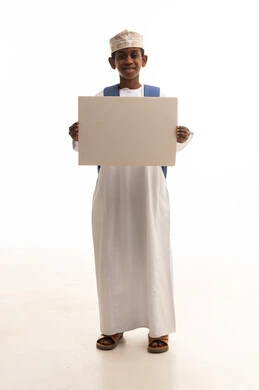 طالب عُماني يحمل لوحة بيضاء فارغة للإعلان
