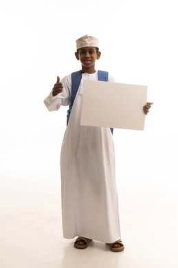 طفل عماني يحمل لوحة بيضاء مع إشارة الإعجاب