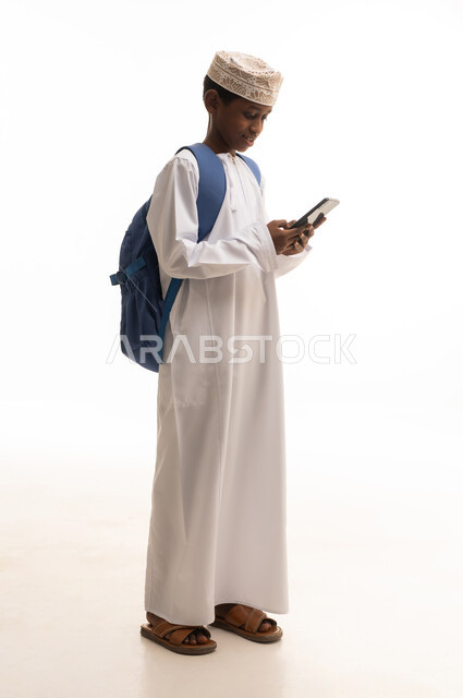 Omani Boy in Traditional Dress Using Smartphone