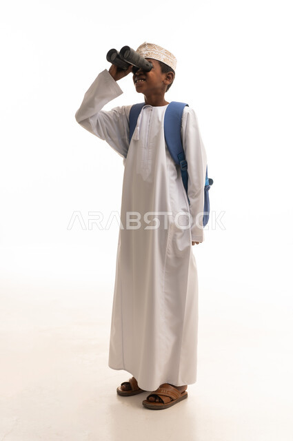 Omani Boy in Traditional Dress Using Binoculars