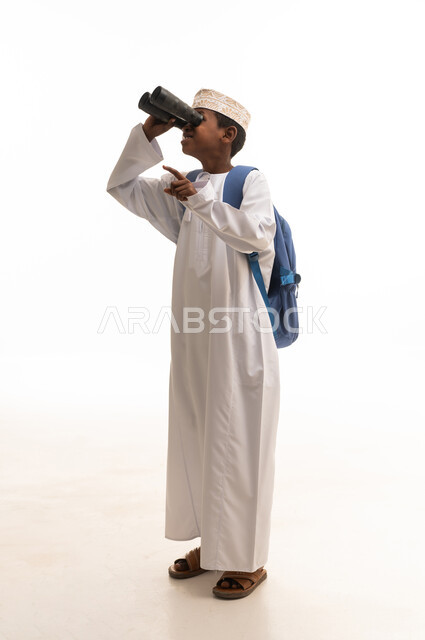 طفل عماني يستخدم المنظار على خلفية بيضاء