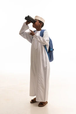 طفل عماني يستخدم المنظار على خلفية بيضاء