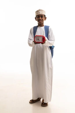 طالب عماني بالزي التقليدي يحمل ساعة منبه