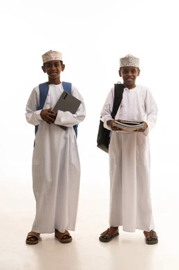 طلاب عمانيون يحملون كمبيوتر وكتباً دراسية خلفية بيضاء