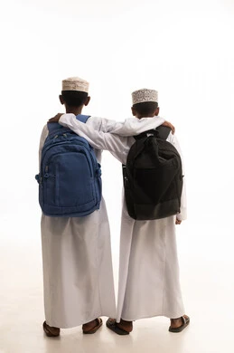 أطفال مدارس عمانيون بحقائب ظهر على خلفية بيضاء