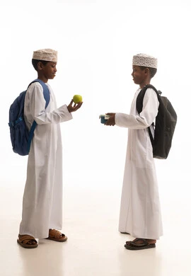 طلاب عُمانيون بالزي التقليدي مع وجبة الغداء