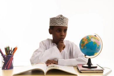 طالب عماني يدرس مجسم الكرة الأرضية في المكتب