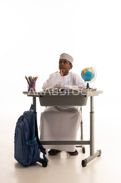 Omani Student Thinking at School Desk on White Background