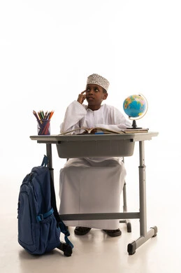 طالب عماني يفكر على مقعد الدراسة بخلفية بيضاء