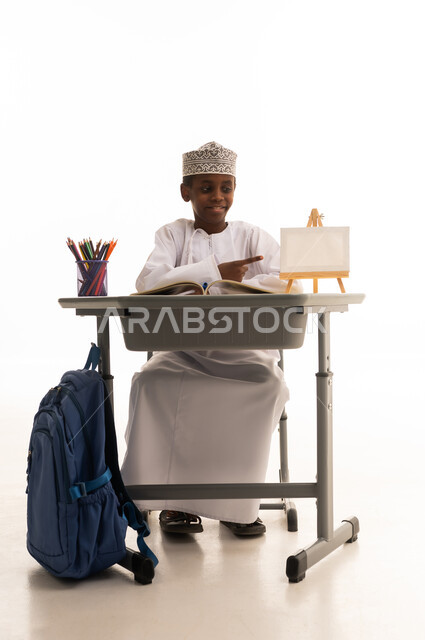 Omani Schoolboy at Desk with Canvas in Studio