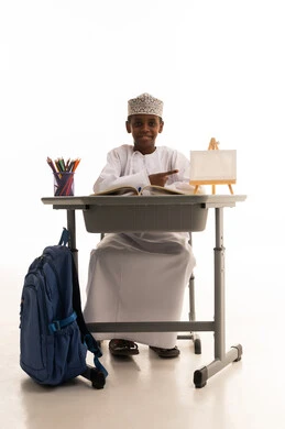 طالب عماني يجلس على مقعد مدرسي